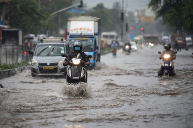MUMBAI / INDIA - 5 AĞUSTOS 2020: Kurla 'da sağanak yağış sırasında sel basmış bir caddede banliyö aracı