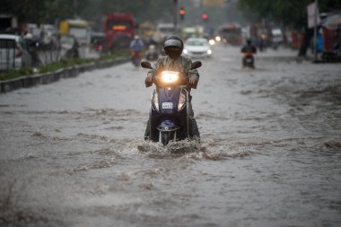 MUMBAI / INDIA - 5 AĞUSTOS 2020: Kurla 'da sağanak yağış sırasında sel basmış bir caddede banliyö aracı