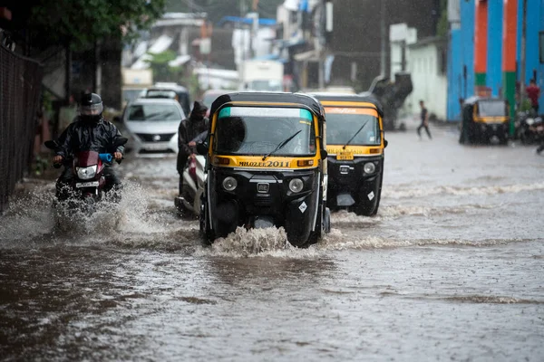 MUMBAI / INDIA - 5 AĞUSTOS 2020: Kurla 'da sağanak yağış sırasında sel basmış bir caddede banliyö aracı