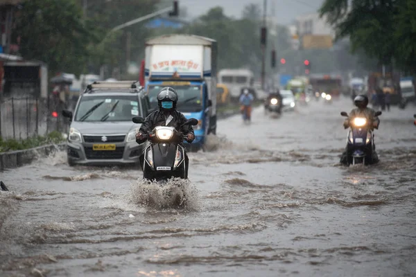 MUMBAI / INDIA - 5 AĞUSTOS 2020: Kurla 'da sağanak yağış sırasında sel basmış bir caddede banliyö aracı