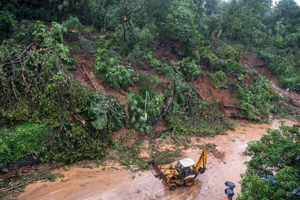 МУМБАЙ / ИНДИЯ - 6 августа 2020 года: Скорая помощь проводит работы по очистке дороги от растительности после оползня на дороге Паддер после недавних сильных муссонных дождей.
