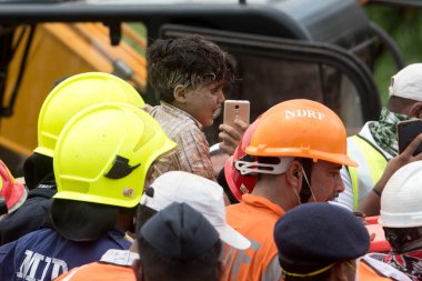 MAHARASHTRA / INDIA - 25 Ağustos 2020: Kurtarma ekipleri, Mahad 'da beş katlı çökmüş bir apartmanın enkazından çıkarılan dört yaşındaki bir çocuğu taşıdılar.