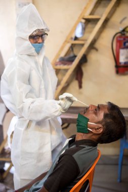 MUMBAI-INDIA - 8 Eylül 2020: Bir tıp çalışanı koronavirüsün yayılmasına karşı önleyici bir önlem olarak COVID-19 Coronavirus test sürücüsünden örnek alır.