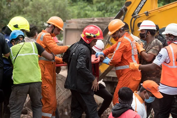 MAHARASHTRA / INDIA - 25 Ağustos 2020: Kurtarma ekipleri, Mahad 'da beş katlı çökmüş bir apartmanın enkazından çıkarılan dört yaşındaki bir çocuğu taşıdılar.