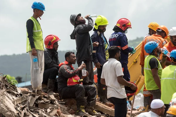 MAHARASHTRA / INDIA - 25 Ağustos 2020: Mahad 'da çöken beş katlı bir apartmanda hayatta kalanları arama çalışmaları sırasında kurtarma ekipleri su içti.