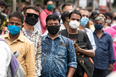 MUMBAI / INDIA - 12 Ekim 2020: Bir Covid-19 koronavirüs salgını sırasında Andheri 'de toplu taşıma otobüsüne binmek için maske takan banliyö sakinleri bekleyin. 