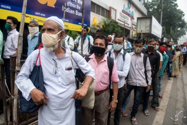 MUMBAI / INDIA - 12 Ekim 2020: Bir Covid-19 koronavirüs salgını sırasında Andheri 'de toplu taşıma otobüsüne binmek için maske takan banliyö sakinleri bekleyin. 
