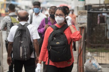 MUMBAI / INDIA - 12 Ekim 2020: Bir Covid-19 koronavirüs salgını sırasında Andheri 'de toplu taşıma otobüsüne binmek için maske takan banliyö sakinleri bekleyin. 