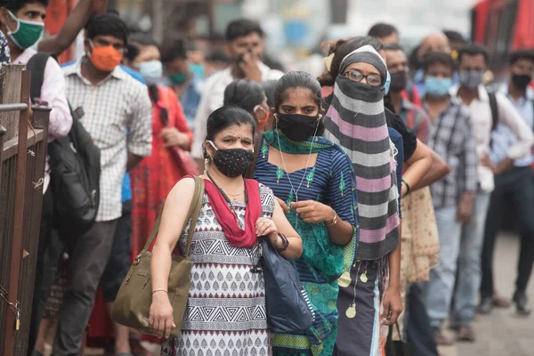 MUMBAI / INDIA - 12 Ekim 2020: Bir Covid-19 koronavirüs salgını sırasında Andheri 'de toplu taşıma otobüsüne binmek için maske takan banliyö sakinleri bekleyin. 