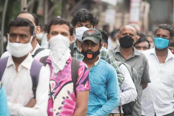 MUMBAI / INDIA - 12 Ekim 2020: Bir Covid-19 koronavirüs salgını sırasında Andheri 'de toplu taşıma otobüsüne binmek için maske takan banliyö sakinleri bekleyin. 