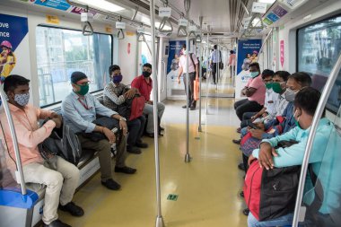 MUMBAI / INDIA - 19 Ekim 2020: Andheri metro istasyonunda metro istasyonunda seyahat ederken maske takan yolcular, Covid-19 Coronavirus salgını nedeniyle metro şebekesi kapandıktan sonra hizmetlerine devam ettiler
