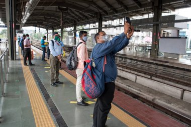 MUMBAI / INDIA - 19 Ekim 2020: Covid-19 Coronavirus salgını nedeniyle metro şebekesi kapandıktan sonra metro istasyonunu bekleyen yolcu.