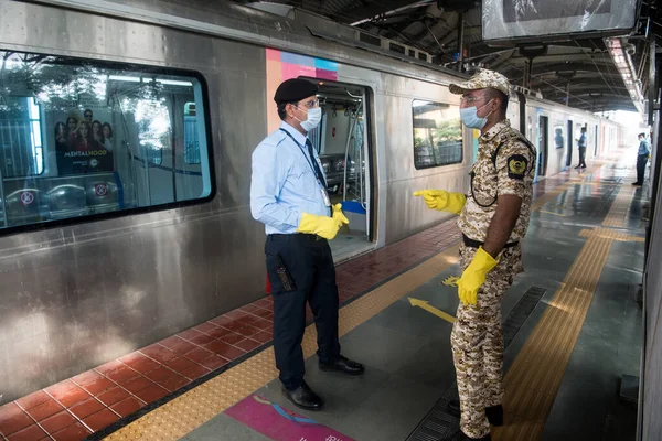 MUMBAI / INDIA - 17 Ekim 2020: Metroda çalışanlar, Andheri 'deki Covid-19 salgını nedeniyle 6 aydan uzun bir süre kapatıldıktan sonra hizmete devam etmeye hazırlanırken tren yakınında bir platformda yürüyorlar.