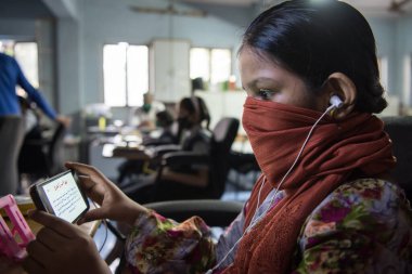MUMBAI / INDIA - 27 Ekim 2020: Covid-19 Coronavirus salgını sırasında Mumbai 'deki Imamwada' da Online Education Mobile Library 'nin bir parçası olarak ders sırasında cep telefonlarında yüz maskesi takan öğrenciler