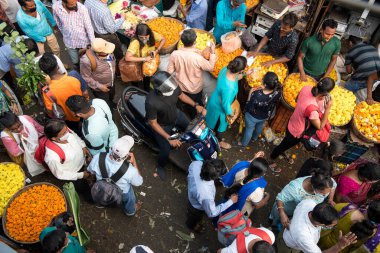 MUMBAI / INDIA - 24 Ekim 2020: Bir motosikletli, Dussehra Hindu festivali vesilesiyle Dadar pazarındaki yaya ve alışveriş merkezlerinin önünden geçiyor. Covid-19 koronavirüs salgını sırasında.
