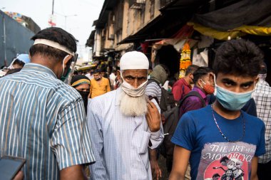 MUMBAI / INDIA - 24 Ekim 2020: Covid-19 Coronavirus salgını sırasında Hindu Dussehra festivali vesilesiyle Dadar pazarında yüz maskesi takan yayalar yürüyorlar.