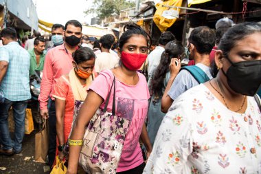 MUMBAI / INDIA - 24 Ekim 2020: Covid-19 Coronavirus salgını sırasında Hindu Dussehra festivali vesilesiyle Dadar pazarında yüz maskesi takan yayalar yürüyorlar.