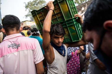 MUMBAI / INDIA - 24 Ekim 2020: Covid-19 Coronavirus salgını sırasında Hindu Dussehra festivali vesilesiyle işçiler Dadar pazarında çiçek sandıkları taşıdılar.