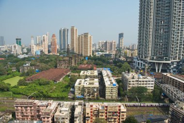 MUMBAI / INDIA - 27 Ekim 2020: Mumbai Parel 'de bir Mumbai yerel treni geçerken, konut ve ticari binaların genel görünümü.