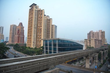 MUMBAI / INDIA - 23 Ekim 2020: Monoray ağı Covid-19 Coronavirus salgını nedeniyle kapatıldıktan sonra hizmetlerine devam ettikten sonra arka planda yerleşim ve ticari tomurcuklanan bir tek raylı köprü.