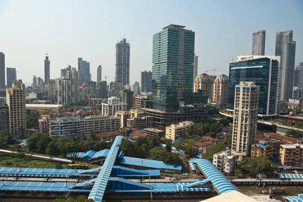 MUMBAI / INDIA - 27 Ekim 2020: Mumbai 'deki Lower Parel istasyonunda bir Mumbai yerel treni geçerken konut ve ticari binaların genel görünümü.