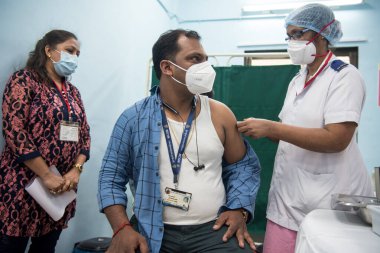 MUMBAI-INDIA - 16 Ocak 2021: Bir tıp çalışanı, bir meslektaşını Rajawadi Hastanesi 'nde Covid-19 Coronavirus aşısıyla aşıladı.