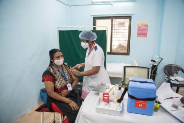 MUMBAI-INDIA - 16 Ocak 2021: Bir tıp çalışanı, bir meslektaşını Rajawadi Hastanesi 'nde Covid-19 Coronavirus aşısıyla aşıladı.