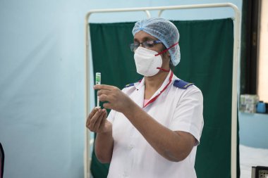 MUMBAI-INDIA - 16 Ocak 2021: Bir tıp çalışanı Rajawadi Hastanesi 'ndeki bir şişeden bir doz Covishield, AstraZeneca' nın Covid-19 Coronavirus aşısı aldı.