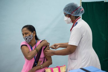 MUMBAI-INDIA - 16 Ocak 2021: Bir tıp çalışanı, bir meslektaşını Rajawadi Hastanesi 'nde Covid-19 Coronavirus aşısıyla aşıladı.