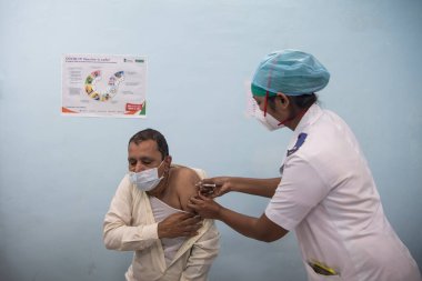 MUMBAI-INDIA - 16 Ocak 2021: Bir tıp çalışanı, bir meslektaşını Rajawadi Hastanesi 'nde Covid-19 Coronavirus aşısıyla aşıladı.