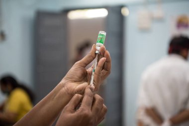 MUMBAI-INDIA - 20 Ocak 2021: Bir tıp çalışanı Rajawadi Hastanesi 'ndeki bir şişeden bir doz Covishield, AstraZeneca' nın Covid-19 Coronavirus aşısı aldı.