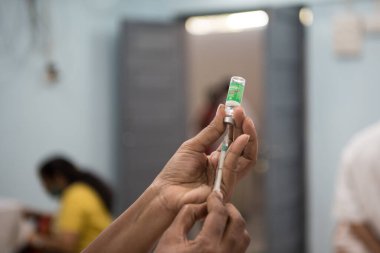 MUMBAI-INDIA - 20 Ocak 2021: Bir tıp çalışanı Rajawadi Hastanesi 'ndeki bir şişeden bir doz Covishield, AstraZeneca' nın Covid-19 Coronavirus aşısı aldı.