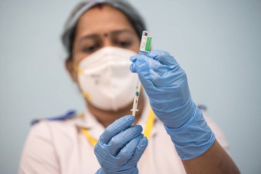 MUMBAI-INDIA - 20 Ocak 2021: Bir tıp çalışanı Rajawadi Hastanesi 'ndeki bir şişeden bir doz Covishield, AstraZeneca' nın Covid-19 Coronavirus aşısı aldı.