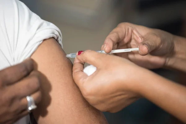 MUMBAI-INDIA - 16 Ocak 2021: Bir tıp çalışanı, bir meslektaşını Rajawadi Hastanesi 'nde Covid-19 Coronavirus aşısıyla aşıladı