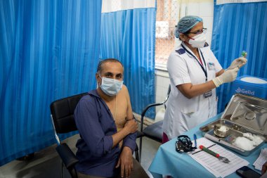 MUMBAI-INDIA - 19 Ocak 2021: Bir tıp çalışanı KEM Hastanesi 'ndeki bir şişeden bir doz Covishield, AstraZeneca' nın Covid-19 Coronavirus aşısı aldı.
