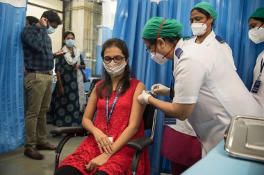 MUMBAI-INDIA - 19 Ocak 2021: Bir tıp çalışanı bir meslektaşına KEM Hastanesi 'nde Covid-19 Coronavirus aşısı aşısı yaptırdı.