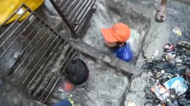 MUMBAI / INDIA - 3 Temmuz 2020: Belediyenin sözleşmeli çalışanı Juhu 'da su boşaltmak için drenaj hattını temizlerken görülüyor.