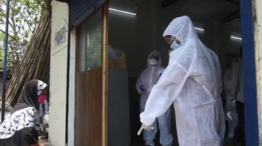MUMBAI / INDIA - MAYIS 1, 2020: COVID-19 Coronavirus 'a karşı önleyici bir önlem olarak Kurla' daki COVID-19 Coronavirus test sürüşü sırasında kadınların vücut sıcaklığını izleyen sağlık çalışanı.