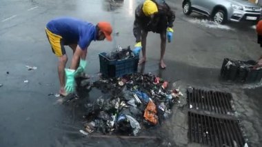 MUMBAI / INDIA - 3 Temmuz 2020: Belediyenin sözleşmeli çalışanı Juhu 'da su boşaltmak için drenaj hattını temizlerken görülüyor.