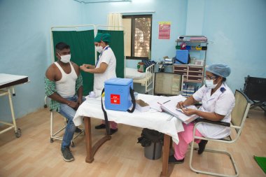 MUMBAI-INDIA - February 9, 2021: A medical staff inoculates a frontline medical worker with a Covid-19 coronavirus vaccine at a vaccination center, Rajawadi Hospital.
