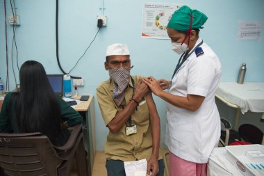 MUMBAI-INDIA - February 10, 2021: A medical staff inoculates a frontline municipal worker with a Covid-19 coronavirus vaccine at a vaccination center, Rajawadi Hospital