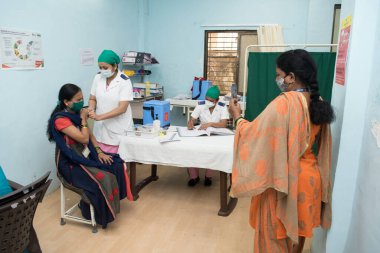 MUMBAI-INDIA - 18 Şubat 2021: Bir tıp çalışanı Rajawadi Hastanesi 'nde Covid-19 Coronavirus aşısı ile bir cephe işçisini aşıladı.