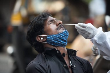 MUMBAI-INDIA - 18 Şubat 2021: Sağlık çalışanları, Chembur 'daki bir cadde boyunca Covid-19 Coronavirus için bir RT- PCR testi için bir adamdan örnek alır..