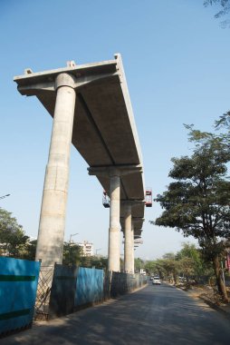MUMBAI - INDIA - March 7, 2021: Concrete pillars on a section of an under construction elevated corridor of The Mumbai Metro Rail project on Jogeshwari  Vikhroli Link Road.