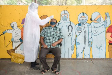 MUMBAI-INDIA - 26 Mart 2021: Sağlık çalışanları Mahim tren istasyonunda Covid-19 Coronavirus için RT- PCR testi için bir adamdan örnek topluyor.