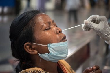 MUMBAI - INDIA - April 2, 2021: Health workers collects a swab sample from a passenger for a RT- PCR test for the Covid-19 coronavirus at Chhatrapati Shivaji Maharaj terminus.