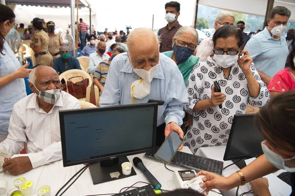 MUMBAI-INDIA - March 1, 2021: People wait to register at a counter for a Covid-19 coronavirus vaccine at the  BKC vaccination center, as the country begins a vaccination programme for senior people.