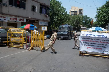 MUMBAI-INDIA-APRIL 7, 2020: COVID-19 Coronavirus 'a karşı önleyici bir önlem olarak Worli köyündeki karantina bölgesine giden yolu engelleyen engeller