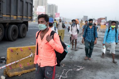 MUMBAI-INDIA - 9 Mayıs 2020: Göçmen işçiler, COVID-19 Coronavirus 'un yayılması ile savaşmak için ülke çapındaki tecrit sürecinde evlerine dönüş yolunda yürüyorlar.
