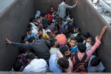 MUMBAI / INDIA - 9 Mayıs 2020: Göçmen işçiler, COVID-19 Coronavirus 'un yayılması ile savaşmak için ülke çapındaki tecrit sırasında otoyolda geri dönüş yolculuklarında kamyonla seyahat ediyorlar.